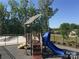 Community playground featuring a blue slide, shade roof, and view of pool and surrounding trees at 435 Galbreath Ct # 128, Fort Mill, SC 29708