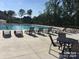 Community pool area with multiple lounge chairs for relaxing poolside with views of the surrounding neighborhood at 435 Galbreath Ct # 128, Fort Mill, SC 29708