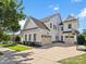 Rear exterior view of a white home with a three car garage and basketball hoop on a large concrete driveway at 435 Galbreath Ct # 128, Fort Mill, SC 29708