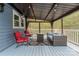 Relaxing back porch with chairs, sofa and a fire table under a protective cover with light at 509 N Oak St, Lincolnton, NC 28092