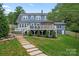 Two story home with a large deck, well manicured lawn, and stone walkway in the backyard at 509 N Oak St, Lincolnton, NC 28092