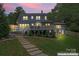 Two story home with a large deck, well manicured lawn, and stone walkway in the backyard at 509 N Oak St, Lincolnton, NC 28092