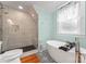 Updated bathroom featuring tile shower, soaking tub and patterned tile floor at 509 N Oak St, Lincolnton, NC 28092