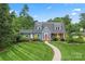 Charming blue two-story home boasts a beautifully landscaped front yard and inviting red door at 509 N Oak St, Lincolnton, NC 28092