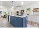 This kitchen has a blue island with a gas cooktop and a dining area in the background at 509 N Oak St, Lincolnton, NC 28092