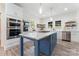 Bright kitchen boasts a blue island, stainless steel appliances, white cabinetry, and charming open shelving at 509 N Oak St, Lincolnton, NC 28092