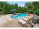 Beautiful kidney shaped pool with patio umbrella, lounge chairs, and lush landscaping at 509 N Oak St, Lincolnton, NC 28092