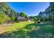 Expansive backyard with lush lawn, mature trees, fire pit, and a play structure at 546 Little Cove Ln, Lake Wylie, SC 29710