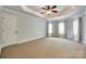 Spacious bedroom featuring tray ceilings, ceiling fan and three windows with neutral colored walls at 546 Little Cove Ln, Lake Wylie, SC 29710