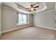 Bedroom featuring a tray ceiling, ceiling fan, carpet, and one window with a window seat at 546 Little Cove Ln, Lake Wylie, SC 29710