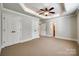 Large bedroom features a tray ceiling, ceiling fan, and multiple closets and entrances at 546 Little Cove Ln, Lake Wylie, SC 29710