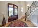 Foyer features wood floors, wrought iron staircase, wood-framed entry door, and decorative rug at 546 Little Cove Ln, Lake Wylie, SC 29710
