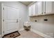 Practical laundry room with overhead cabinets, sink, and easy access to an exterior door at 546 Little Cove Ln, Lake Wylie, SC 29710