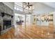 Open-concept living room with hardwood flooring, fireplace, and seamless flow to dining area and kitchen at 546 Little Cove Ln, Lake Wylie, SC 29710