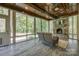 Bright sunroom with a stone fireplace, wood ceiling, and views of the landscaped backyard at 546 Little Cove Ln, Lake Wylie, SC 29710