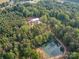 Aerial view of red barn style home with surrounding acreage and pond at 574 Crescent Rd, Rockwell, NC 28138