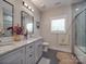 Bright bathroom features dual sinks, granite countertops, and a shower-tub with gray-tone ceramic tile at 574 Crescent Rd, Rockwell, NC 28138