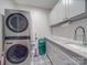 Well-organized laundry room with stacked washer/dryer, sink with granite countertop, and ample storage at 574 Crescent Rd, Rockwell, NC 28138