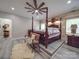 Bedroom with unique platform, four-poster bed, wood accent wall, and a statement ceiling fan at 574 Crescent Rd, Rockwell, NC 28138