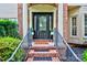 Inviting front entrance with brick steps, black railings, and a decorative glass door at 6206 Glencairn Ct, Charlotte, NC 28269