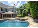 Gorgeous pool area with a stone spa and waterfall feature surrounded by greenery at 6206 Glencairn Ct, Charlotte, NC 28269