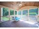 Inviting screened-in porch with a comfortable daybed swing, brick flooring and wood paneled ceiling at 6206 Glencairn Ct, Charlotte, NC 28269