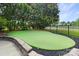 Backyard putting green surrounded by lush greenery and a fence for privacy at 6206 Glencairn Ct, Charlotte, NC 28269