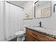 Renovated bathroom vanity with granite countertops, sleek black faucet, black hardware and shower with white curtain at 632 Skyland N Dr, Mount Pleasant, NC 28124