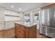 Charming kitchen with stainless steel refrigerator and center island, granite countertops, and natural light at 632 Skyland N Dr, Mount Pleasant, NC 28124