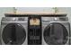 Modern laundry room featuring gray Samsung washer and dryer with a wooden shelf and decorative plants at 632 Skyland N Dr, Mount Pleasant, NC 28124