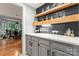 Chic bar area with dark backsplash, floating shelves, stylish glassware, and grey lower cabinetry at 6432 Morningsong Ln, Charlotte, NC 28269