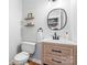 Charming powder room with wood vanity, round mirror and elegant fixtures at 6432 Morningsong Ln, Charlotte, NC 28269