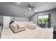 Spacious bonus room featuring a large sectional, peloton, and ceiling fan at 6432 Morningsong Ln, Charlotte, NC 28269