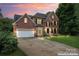 Gorgeous brick home with manicured lawn and inviting driveway, dusk view at 6432 Morningsong Ln, Charlotte, NC 28269