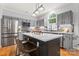 Beautiful kitchen featuring grey cabinetry, stainless steel appliances, and a large center island with bar seating at 6432 Morningsong Ln, Charlotte, NC 28269