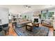 Open concept living room with brick fireplace, hardwood floors, and access to the kitchen at 6432 Morningsong Ln, Charlotte, NC 28269