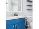 Bathroom vanity features a blue cabinet, marble countertop, and modern fixtures, with floating shelves above toilet at 6443 Mallard View Ln, Charlotte, NC 28269
