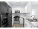 Well-lit kitchen featuring stainless steel appliances, white cabinets, and granite countertops at 6443 Mallard View Ln, Charlotte, NC 28269