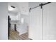 Modern kitchen with stainless appliances, white cabinets, granite countertops, and a convenient sliding barn door at 6443 Mallard View Ln, Charlotte, NC 28269