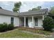 Charming white home featuring a covered porch, updated windows, and neatly manicured landscaping at 6507 Chewink Ct, Charlotte, NC 28227
