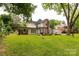 Expansive backyard with lush greenery, a brick patio, and a charming exterior view of the home at 7 Kings Mountain St, York, SC 29745