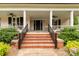Inviting front porch features classic columns and is adorned with beautiful plants and a charming swing at 7 Kings Mountain St, York, SC 29745
