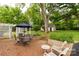 Outdoor brick patio area featuring an umbrella-covered dining table and a lovely, landscaped yard at 7 Kings Mountain St, York, SC 29745