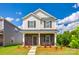 Charming two-story home featuring stone accents, a cozy porch, and manicured landscaping at 700 Windage Way, Pineville, NC 28134