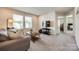 Comfortable living room featuring a plush sofa, coffee table, and ample natural light streaming through large windows at 700 Windage Way, Pineville, NC 28134