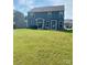 Expansive backyard features a lush lawn and a large, modern two-story home with a patio at 7024 Wheyfield Dr, Charlotte, NC 28215