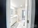 Bright bathroom with dual sinks, neutral tile flooring, and white cabinets at 7024 Wheyfield Dr, Charlotte, NC 28215