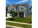 Charming two-story home featuring a well-manicured lawn and a combination of blue and gray siding at 7024 Wheyfield Dr, Charlotte, NC 28215