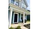 Inviting front porch with white pillars and dark siding, offering a cozy outdoor seating area at 7024 Wheyfield Dr, Charlotte, NC 28215