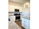 Well-lit kitchen with granite counters, white cabinets, subway tile backsplash and stainless appliances at 7024 Wheyfield Dr, Charlotte, NC 28215